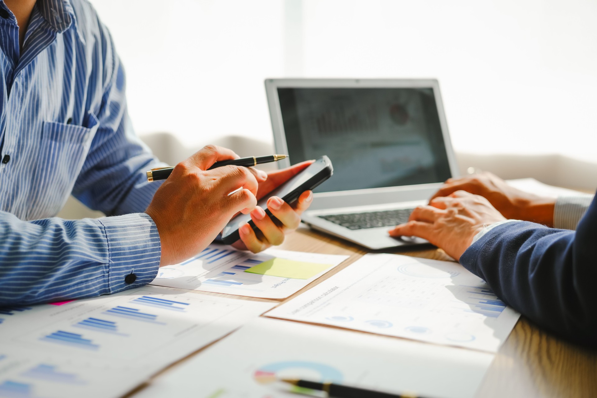 Desk-bound businessman calculates figures, verified accounts, and collaborates in discussions. Proficient in using calculators, aiding each other, and managing annual tax accounts in the audit office