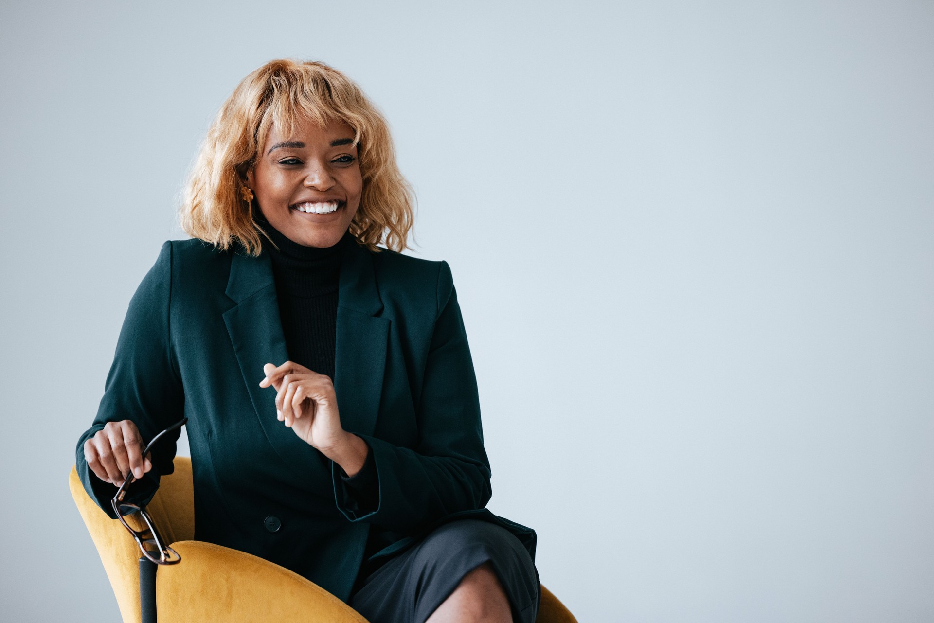 Smiling Businesswoman in Office with Blonde Hair and Glasses